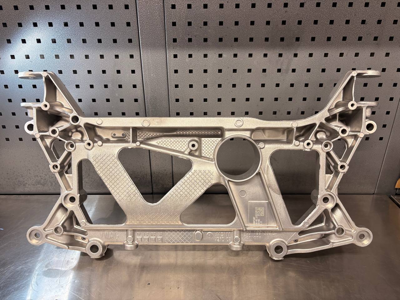 VW cast-aluminium automotive subframe with a clean satin finish after VMC vapour blasting